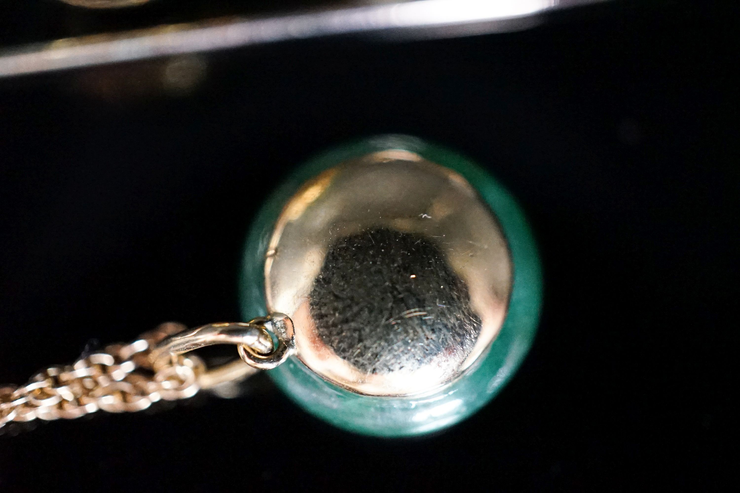 A yellow metal mounted jade and diamond set circular pendant, 14mm, on a 585 rope twist chain and a similar jade and diamond set bar brooch, 58mm, gross weight 12.8 grams